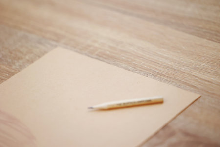 Blank paper with pencil on wooden table background, selective focus.