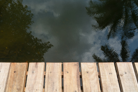 Wooden bridge and water reflectionsの写真素材