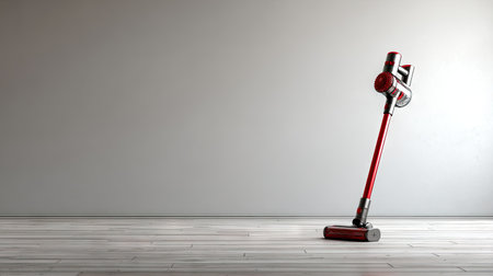 A vibrant red stick vacuum cleaner stands elegantly on a wooden floor, showcasing modern design and functionality in a minimalist setting ideal for contemporary homes.の素材