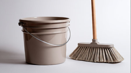 A clean and simple setup featuring a beige bucket and broom, perfect for household chores and maintenance. This image conveys minimalism and functionality, ideal for home improvement projects and cleaning applications.の素材