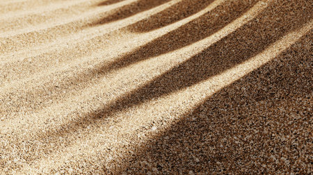 This detailed close-up of desert sand features soft shadows and smooth textures. The warm tones of the sand create a serene and peaceful atmosphere.の素材