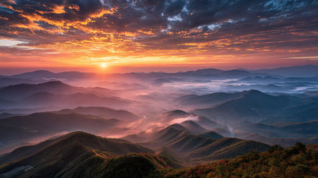Experience the serene beauty of a stunning sunrise over majestic mountains, where vibrant skies meet soft fog in the valley below, creating a tranquil landscape.の素材