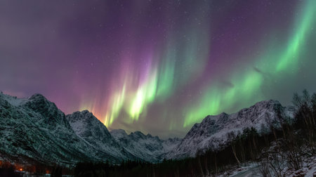 Experience the breathtaking beauty of the aurora borealis as it dances across a snowy landscape, illuminating the towering mountains under a starry night sky.の素材