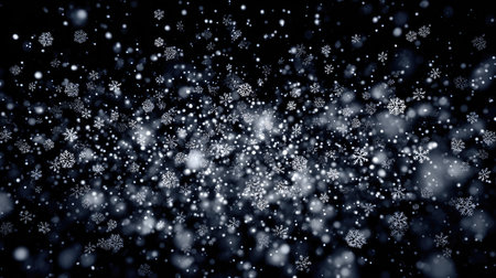 A mesmerizing scene of snowflakes softly falling against a dark night sky, evoking feelings of tranquility and wonder during the winter season.の素材