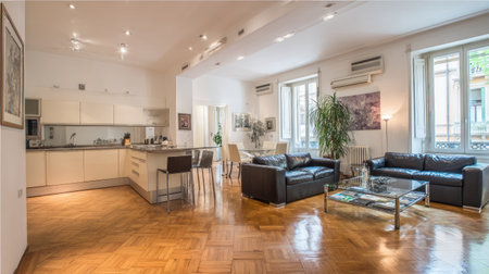 Bright and airy modern living room with an open kitchen arrangement. The stylish decor includes comfortable seating and vibrant plants, creating an inviting ambiance.の素材