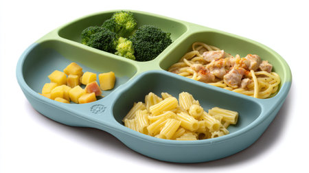A vibrant divided plate showcases a balanced meal featuring pasta, chicken, fresh broccoli, and fruit cubes, perfect for promoting healthy eating habits.の素材