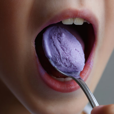A captivating close-up image showcasing a child's joyful expression while eating a scoop of purple ice cream with a spoon, emitting happiness and delight.の素材