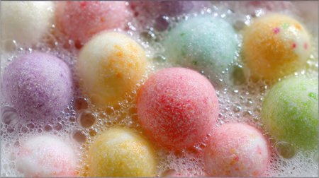 Delight in the enchanting view of colorful bath bombs floating playfully in bubbly water, ideal for a soothing spa session or a home pampering routine.の素材