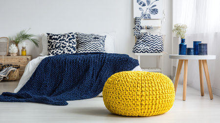 A stylish bedroom featuring a harmonious blend of navy blue and white decor, complemented by a bright yellow pouf, creating a cozy atmosphere.の素材
