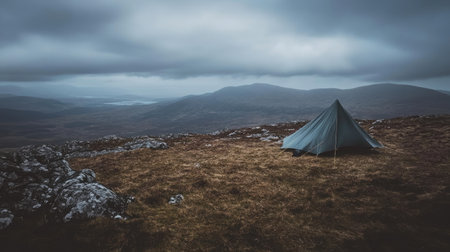 Captivating view of a lone tent set against a vast highland landscape, featuring dramatic clouds and a tranquil atmosphere perfect for outdoor adventures.の素材