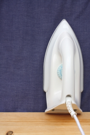 Electric iron  on blue cloth backgroundの写真素材
