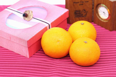 Orange and gift box on red backgroundの写真素材