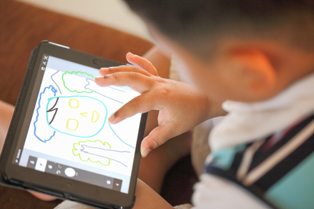 Hand of Asian boy playing Tablet funの写真素材