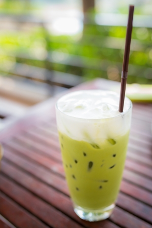 Green tea smoothie on wooden table, natural backdropの写真素材