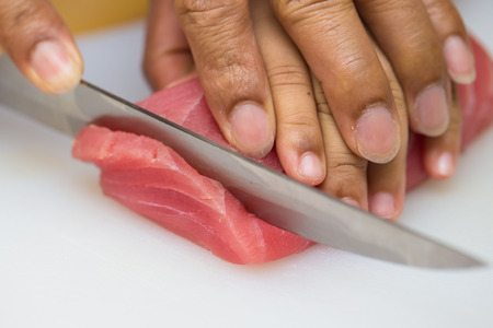 Hand was sliced ââfish to make sushiの写真素材