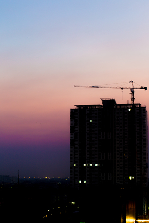 Crane on a building, image silhouette at sunsetの写真素材