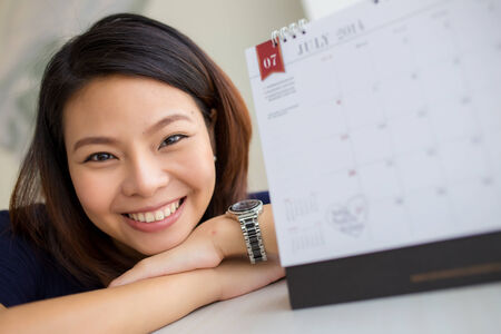 Beautiful pregnant woman looking at the calendar for the date of birth