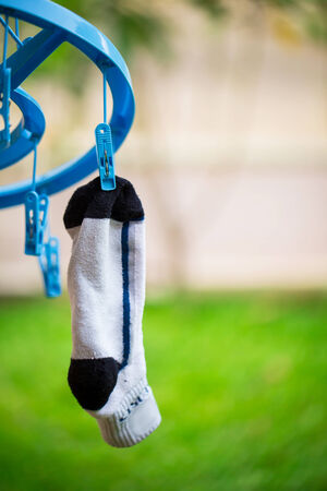 white sock on washing line with wooden clothes peg and bubblesの写真素材