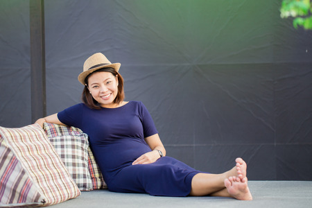 young pregnant woman sitting,charming smileの写真素材