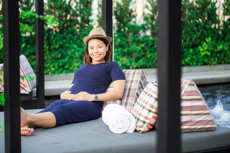 young pregnant woman sitting,charming smileの写真素材