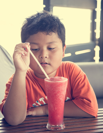 Cute boy drinking watermelon juiceの写真素材