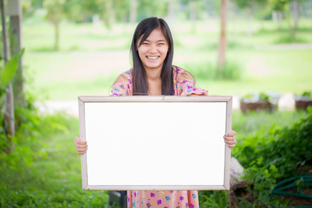 Portrait of young woman with blank white boardの写真素材