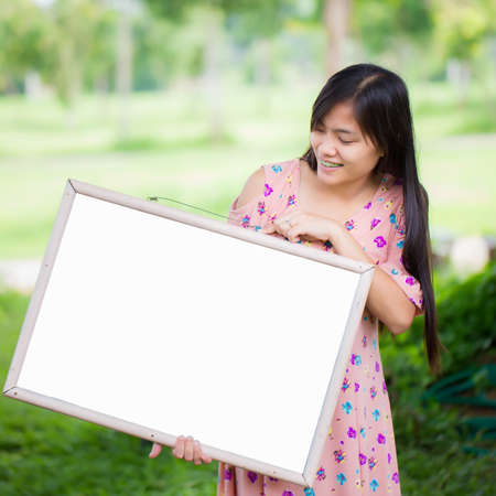 Portrait of young woman with blank white boardの写真素材