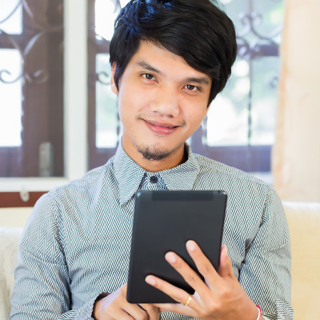 Serious young male executive using digital tabletの写真素材