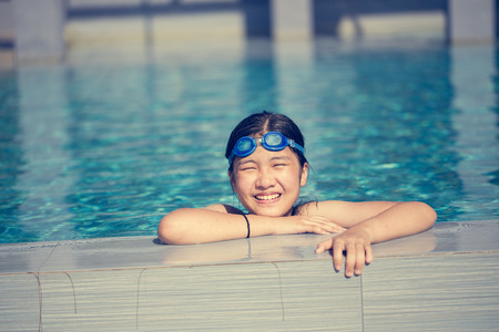 little girl playing in swimming poolの写真素材