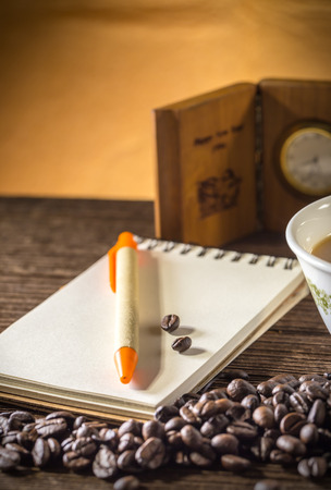 Still life of Pencil on a white spiral squared notebook with cup of coffeeの写真素材