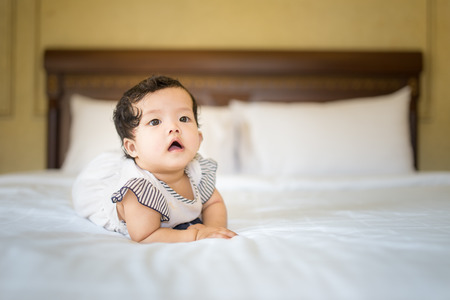 laughing baby,cheerful on the bed,Looks are doing wonderの写真素材