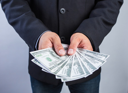 Businessman hand gripping money, US dollar (USD) bills - investment, business conceptsの写真素材