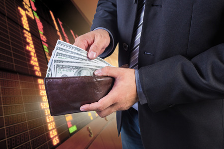 Businessman hand gripping money, US dollar (USD) bills - investment, business conceptsの写真素材