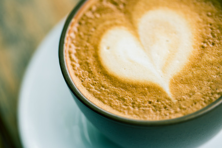 cup of latte art coffee on wood tableの写真素材