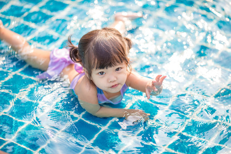 little girl swimming in outdoor pool and have a funの写真素材