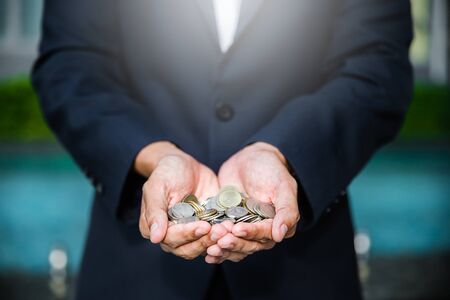 A coins in people hands in saving money conceptの写真素材