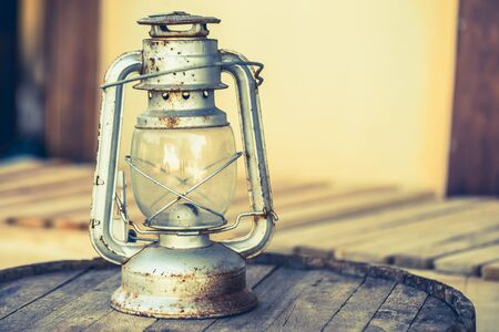 vintage kerosene oil lantern lamp burning with a soft glow light in an antique rustic country barn...