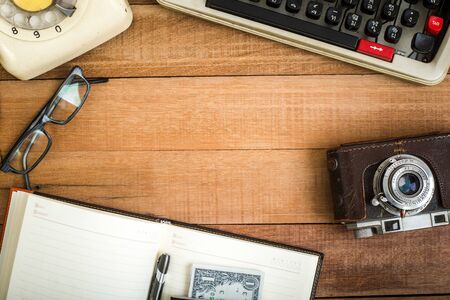 Top view of notebook on the wood table , typewriter, old telephone and earphoneの写真素材