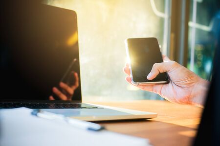 Businessman using laptop and mobile phone