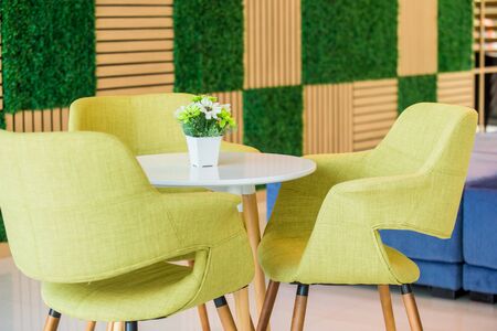 Beautiful fake flower in vase on white table in roomの写真素材