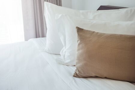 white pillows and bed sheets in beauty room'の写真素材