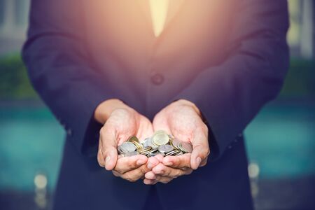 A coins in people hands in saving money conceptの写真素材