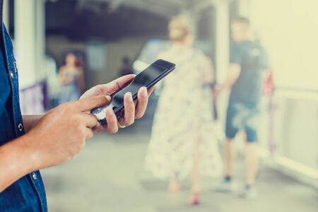 Close-up view of an Asian businessman using digital smart phone in the cityの写真素材