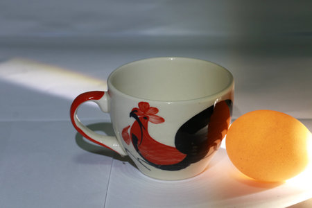 Close up white cup's chicken painting and transparency egg shell on white groundの写真素材