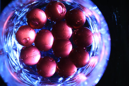 Close up transparency colorful jelly balls on small glass dish on black backgroundの写真素材