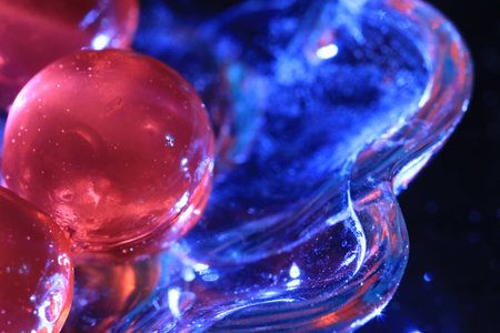 Close up transparency colorful jelly balls on small glass dish on black backgroundの写真素材