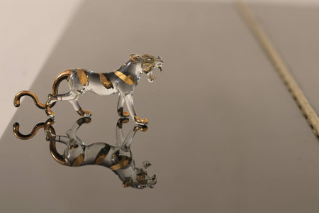 Close up the small crystal tiger and reflection on the groundの写真素材
