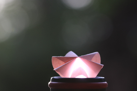 Close up transparency colorful paper flower and white bokeh on green backgroundの写真素材