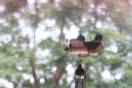 Close up small hanging wood plane and white bokeh on green backgroundの写真素材