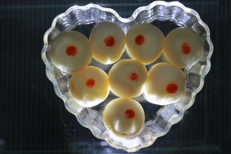 Top view of chinese pastry on transparency heart glass dish on black groundの写真素材